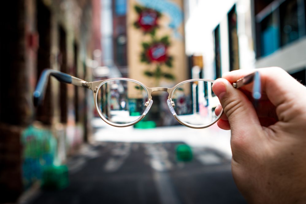 Pessoa segurando óculos que mostra única parte focada ad imagem