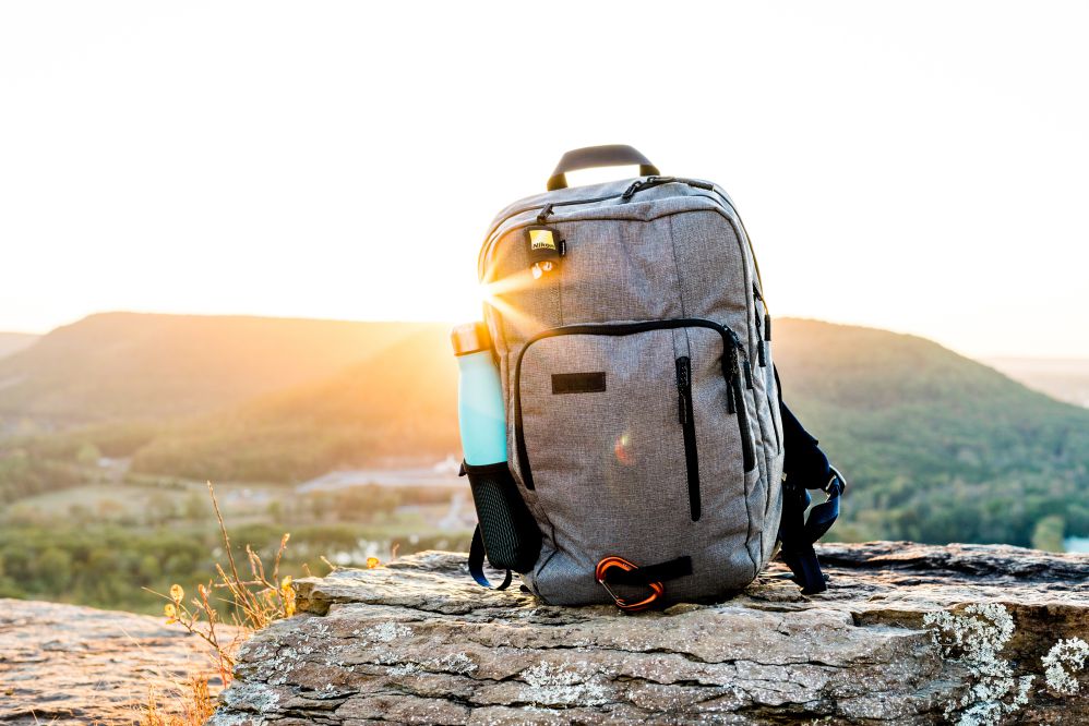 Mochila em cima de uma pedra com paisagem ao fundo